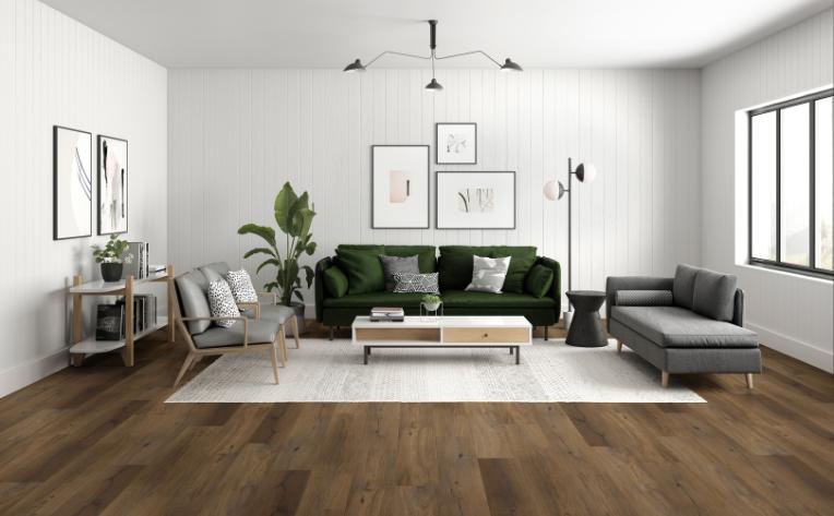 laminate flooring in living room with green couch and lighting.